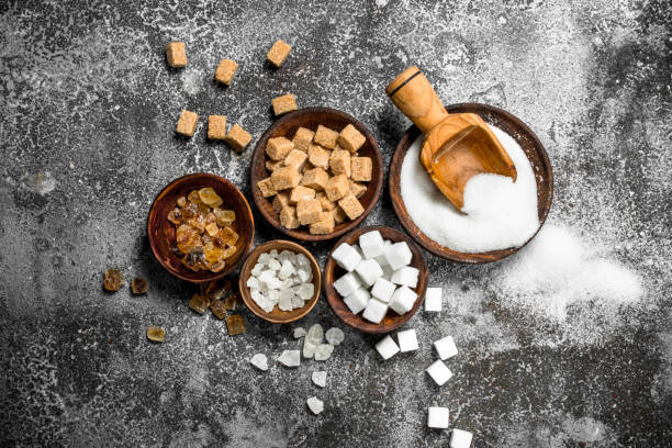 Different kinds of sugar in bowls. On a rustic background.